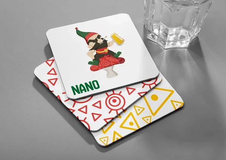 הדמיה של תחתיות כוס של NANO: אלנאנו עם כוס בירה, הלוגו בירוק ודפוסים גיאומטריים באדום ובצהוב