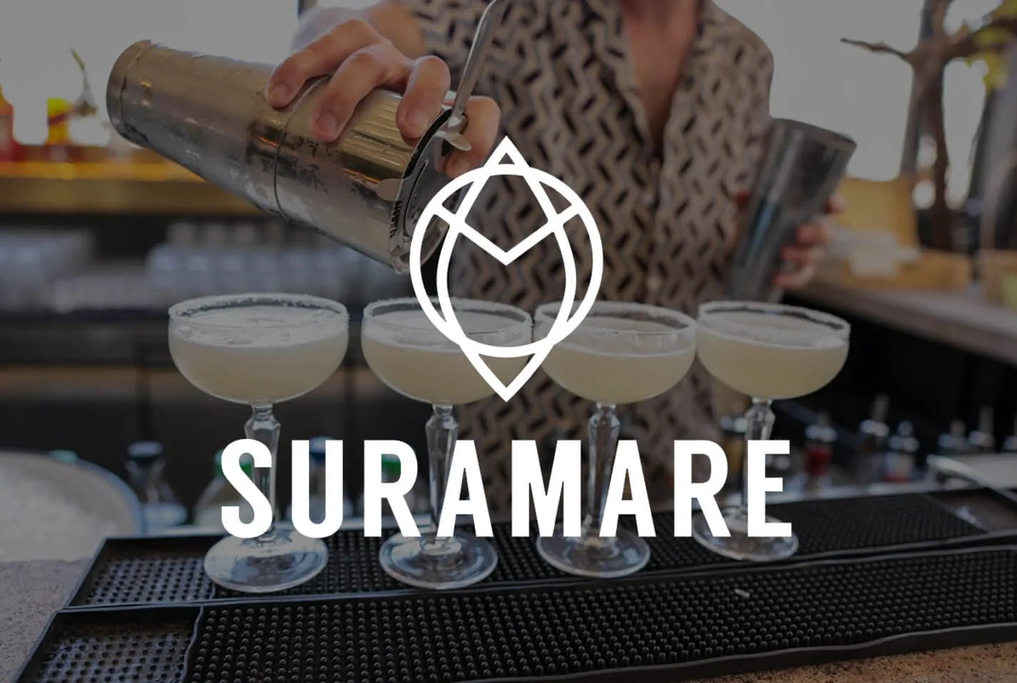 לוגו Suramare מעל צילום של ברמן שמוזג קוקטיילים לכוסות